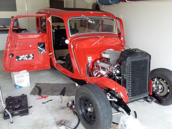 A red hot rod mid build in a garage